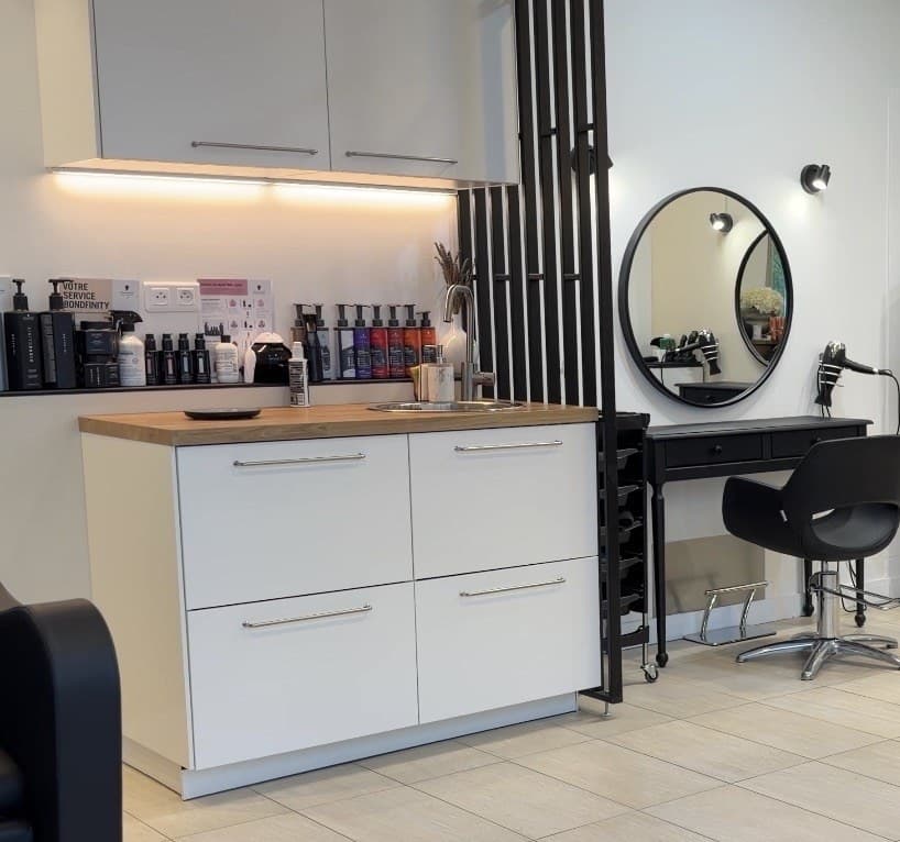 Intérieur du salon Le Miroir — comptoir, claustra, miroir et coiffeuse